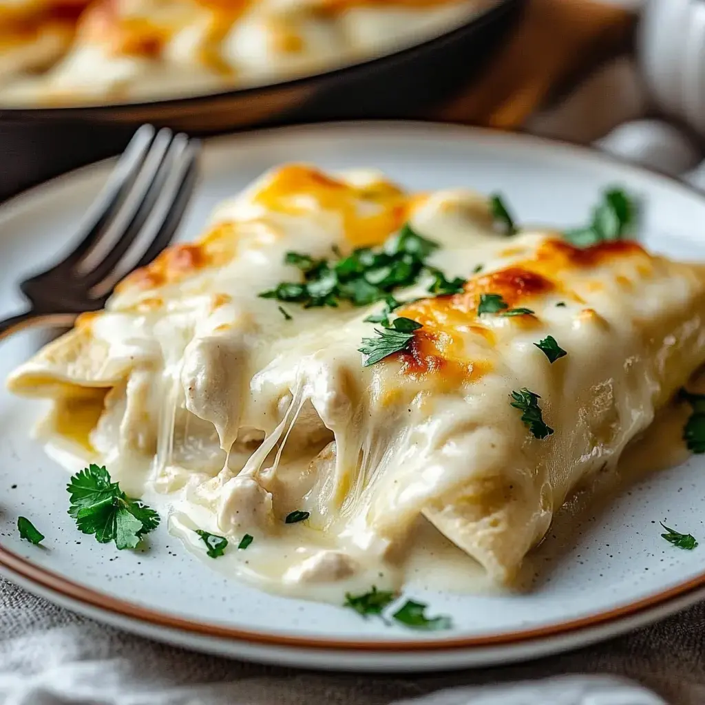 A plate of cheesy chicken enchiladas topped with melted cheese and garnished with fresh parsley.