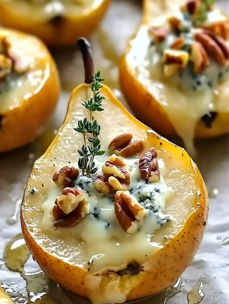 Baked halved pears topped with blue cheese, chopped pecans, and a sprig of thyme, drizzled with honey.