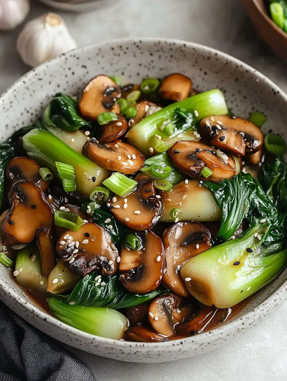 A bowl of sautéed bok choy and mushrooms garnished with green onions and sesame seeds.