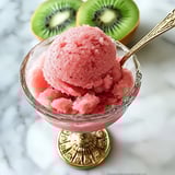 A glass of pink frozen fruit.