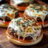 A close up of a cheesy burger on a bun.