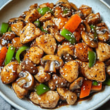 A plate of food with mushrooms, carrots, and peppers.